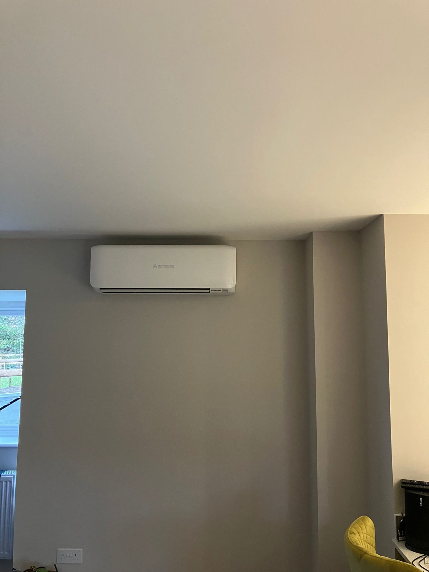 Wall-mounted Mitsubishi AC unit in living room