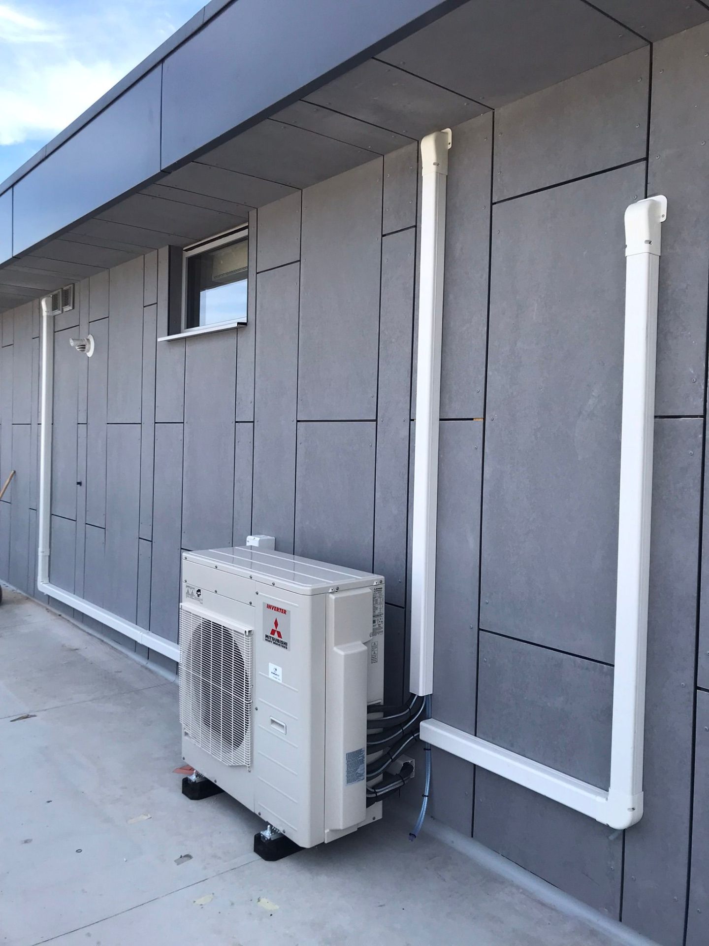 Mitsubishi outdoor unit with trunking on modern building