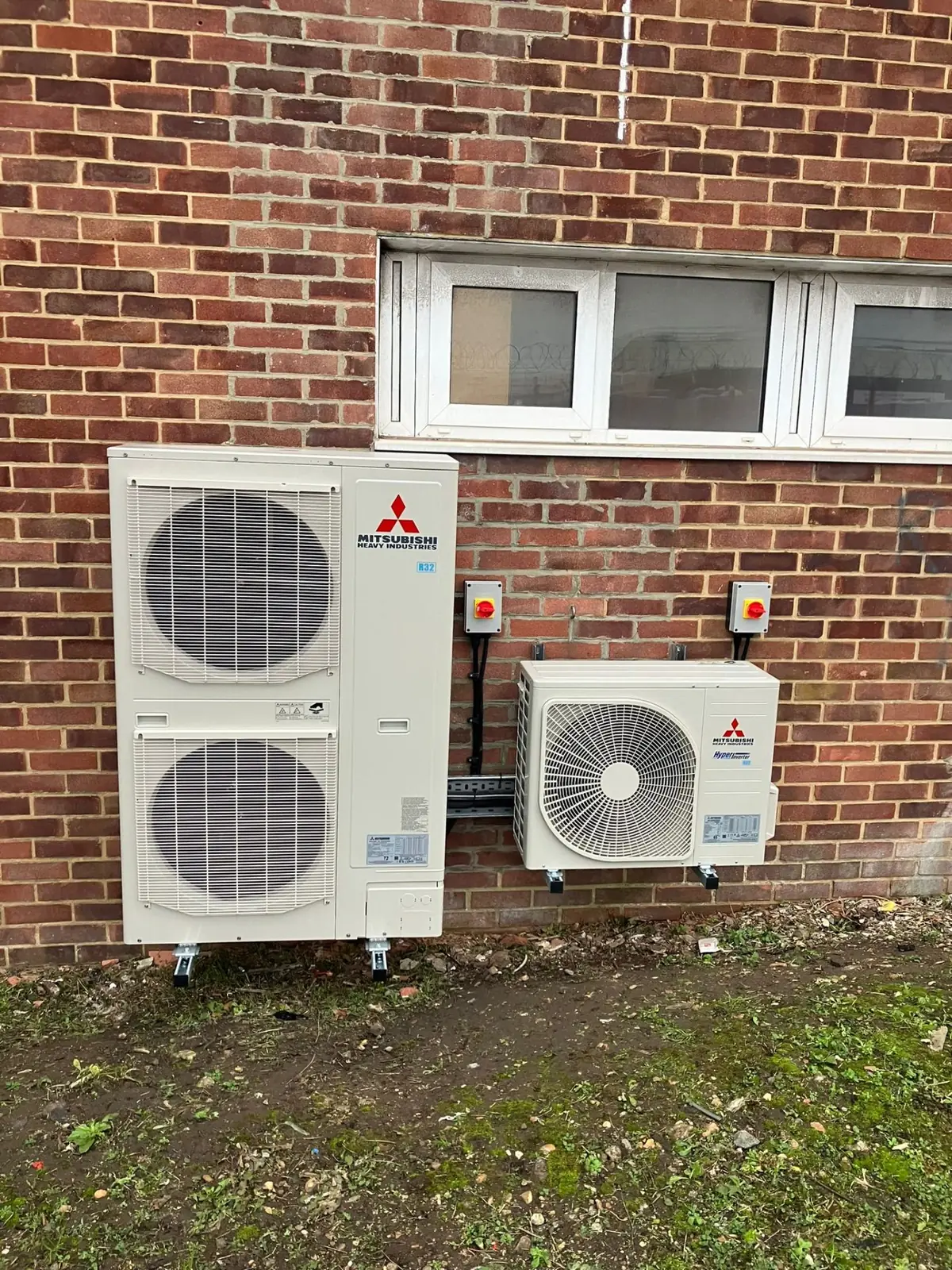Mitsubishi outdoor condensers mounted on brick wall