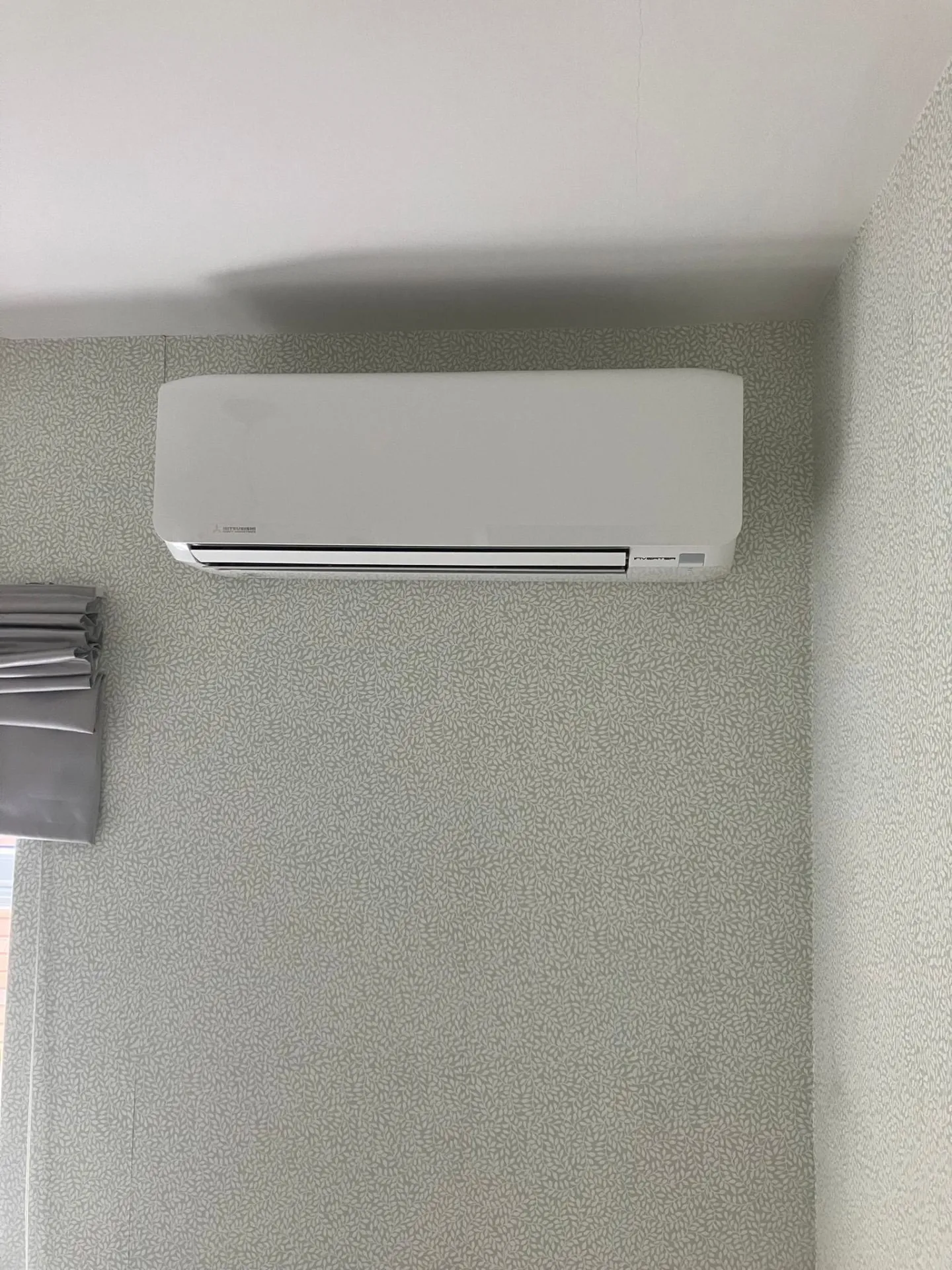 Wall-mounted Mitsubishi AC unit in bedroom