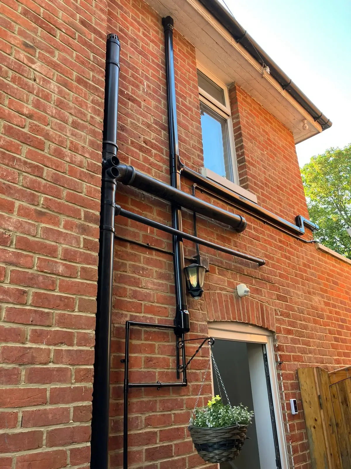 Neat external pipework installation on brick house